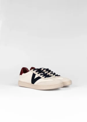 Zapatilla casual con estética minimalista. Parte superior de efecto piel con detalles en contraste en el lateral y el talón. Suela de goma flexible para mayor confort. Diseño versátil para un estilo urbano y sofisticado.